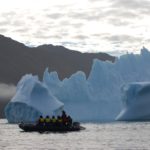 Zodiac cruising past an iceberg