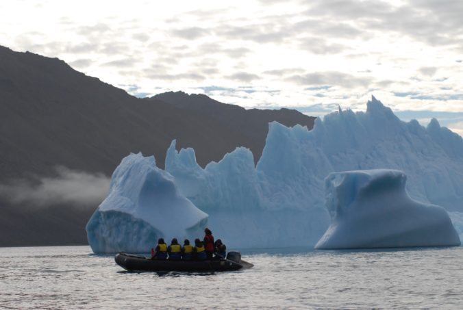 Zodiac cruising past an iceberg